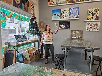 Woman taking selfie in front of paintings