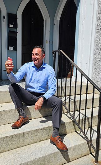 Joe Distefano sitting on steps taking selfie